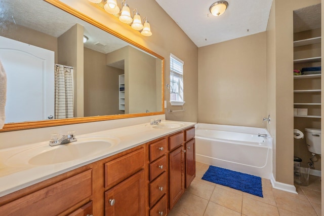 bathroom featuring a sink, double vanity, a bath, and tile patterned floors