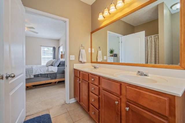 bathroom with tile patterned floors, double vanity, ensuite bathroom, and a sink