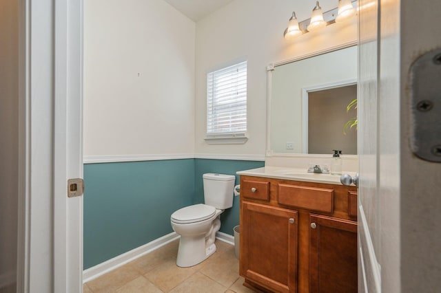 bathroom with tile patterned flooring, toilet, vanity, and baseboards