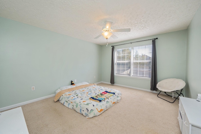 bedroom featuring ceiling fan, light colored carpet, baseboards, and a textured ceiling