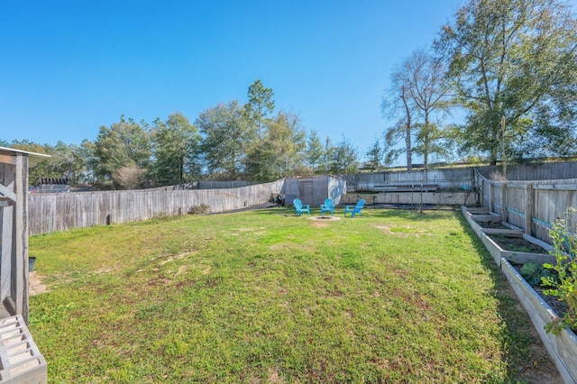 view of yard with a fire pit and a fenced backyard