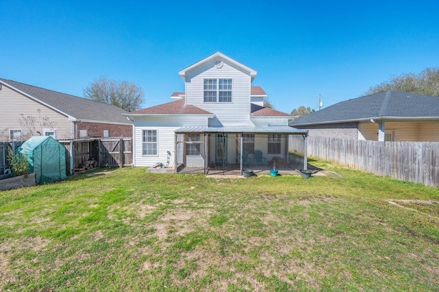 back of property featuring a patio area, a lawn, a fenced backyard, and a sunroom