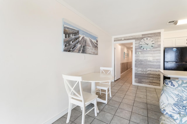 dining area with light tile patterned floors, baseboards, visible vents, and ornamental molding