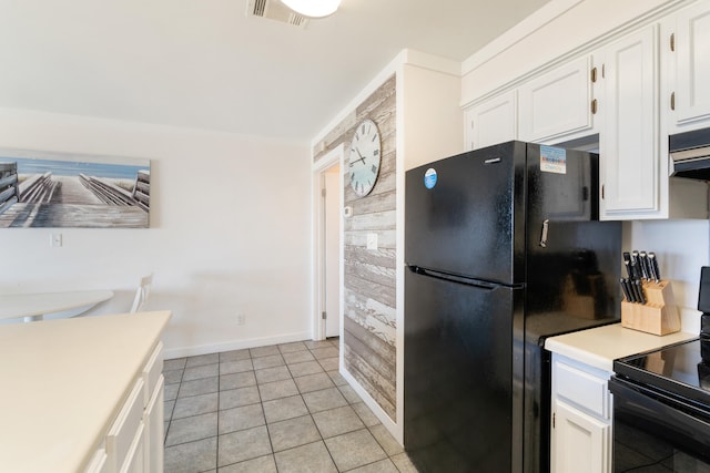 kitchen with visible vents, light countertops, light tile patterned floors, white cabinets, and black appliances