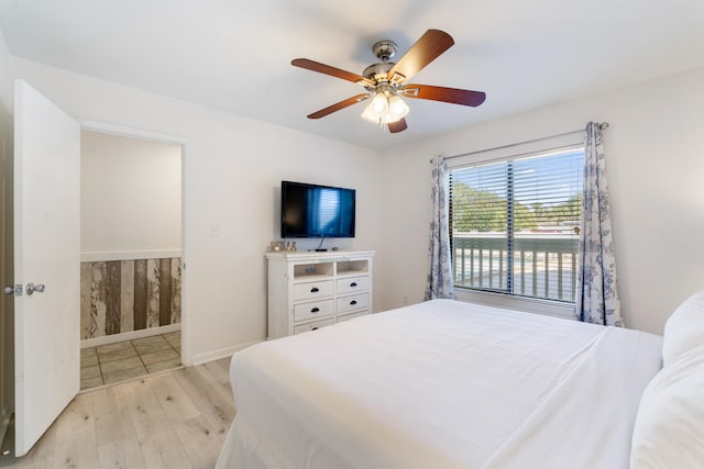 bedroom with baseboards, light wood-style floors, and a ceiling fan