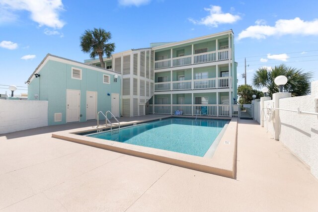 community pool featuring a patio area and fence