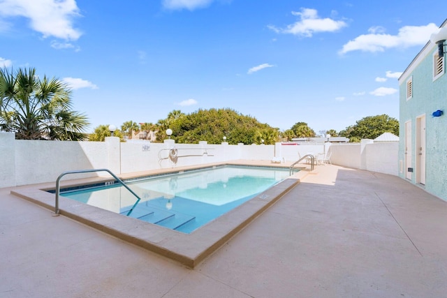 community pool featuring a patio and a fenced backyard