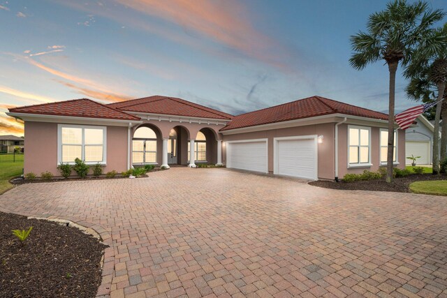 114 Golf Dr, Panama City Beach, FL 32408 - mediterranean / spanish home featuring stucco siding, an attached garage, decorative driveway, and a tile roof