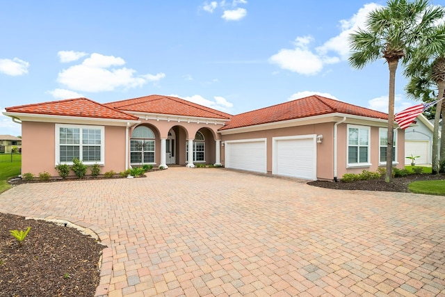 114 Golf Dr, Panama City Beach, FL 32408 - mediterranean / spanish-style home featuring stucco siding, a garage, a tile roof, and decorative driveway