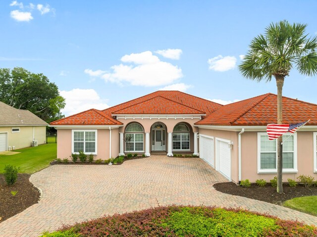 114 Golf Dr, Panama City Beach, FL 32408 - mediterranean / spanish house featuring a garage, stucco siding, driveway, and a tiled roof