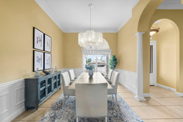 114 Golf Dr, Panama City Beach, FL 32408 - dining space featuring arched walkways, ornamental molding, a wainscoted wall, light tile patterned flooring, and a decorative wall