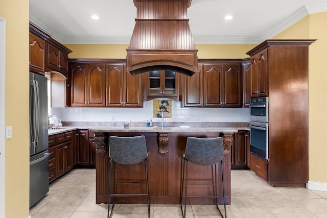 114 Golf Dr, Panama City Beach, FL 32408 - kitchen with freestanding refrigerator, a kitchen island, crown molding, light tile patterned flooring, and a kitchen bar
