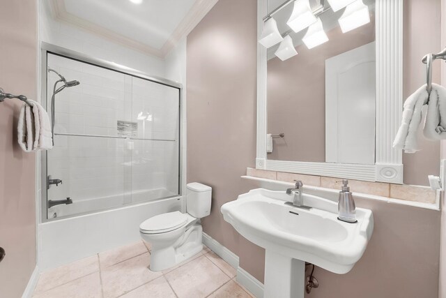 114 Golf Dr, Panama City Beach, FL 32408 - full bath featuring crown molding, toilet, tile patterned floors, baseboards, and bath / shower combo with glass door