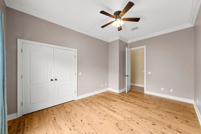 114 Golf Dr, Panama City Beach, FL 32408 - unfurnished bedroom featuring light wood-style flooring, crown molding, baseboards, ceiling fan, and a closet