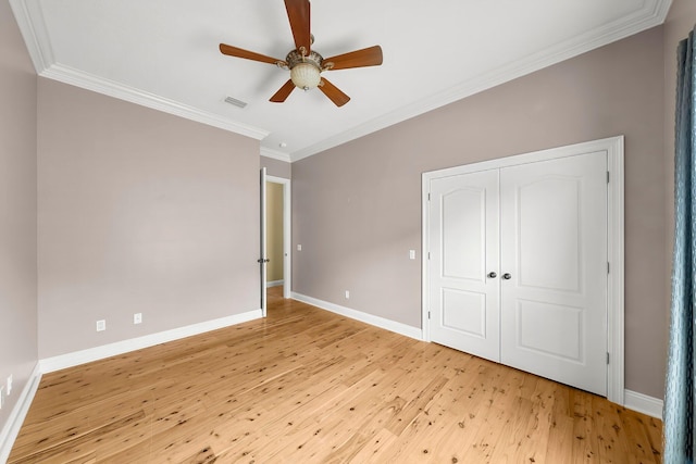 114 Golf Dr, Panama City Beach, FL 32408 - unfurnished bedroom featuring light wood-style floors, ornamental molding, baseboards, a closet, and a ceiling fan