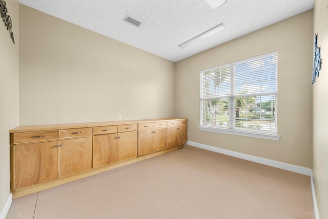 114 Golf Dr, Panama City Beach, FL 32408 - empty room with baseboards, finished concrete flooring, a textured ceiling, and vaulted ceiling
