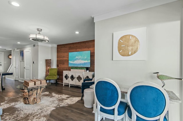 interior space featuring wooden walls, an accent wall, crown molding, recessed lighting, and wood finished floors