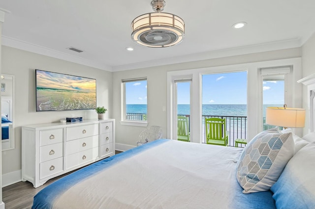 bedroom featuring ornamental molding, wood finished floors, a water view, and access to outside