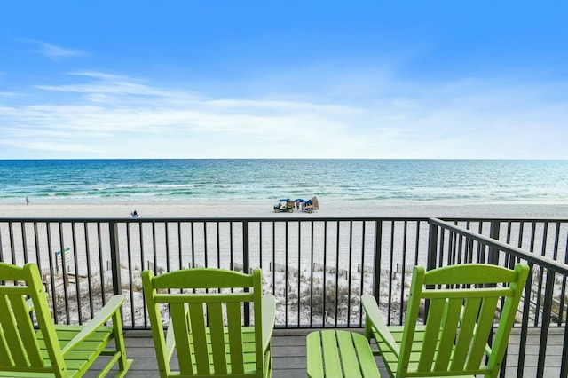 balcony with a water view and a beach view