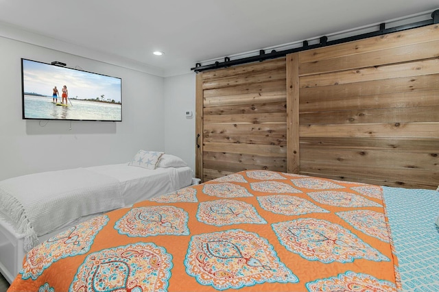 bedroom with recessed lighting and a barn door