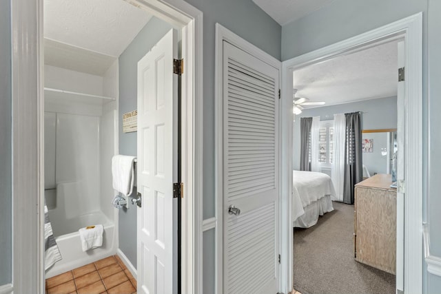 ensuite bathroom with a ceiling fan, tile patterned flooring, a textured ceiling, shower / bathtub combination, and connected bathroom