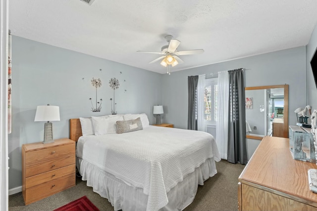 bedroom with ceiling fan and dark colored carpet