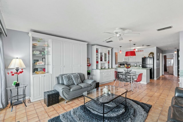 living area with light tile patterned floors, visible vents, and a ceiling fan