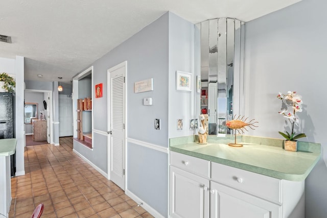 interior space with light tile patterned floors, visible vents, and baseboards