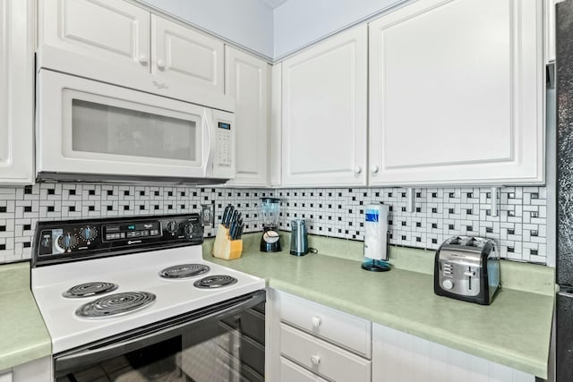 kitchen featuring white cabinetry, electric range, white microwave, and backsplash