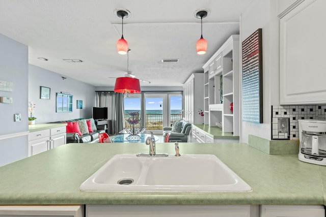 kitchen featuring a sink, visible vents, pendant lighting, and open floor plan