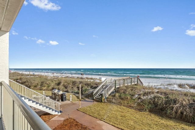 water view with stairway and a view of the beach