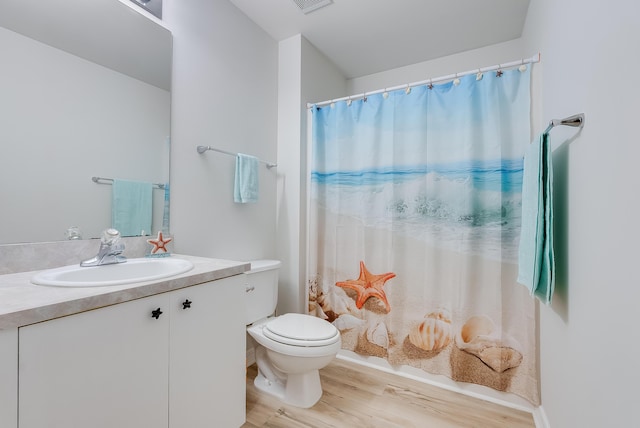 bathroom with visible vents, curtained shower, toilet, wood finished floors, and vanity