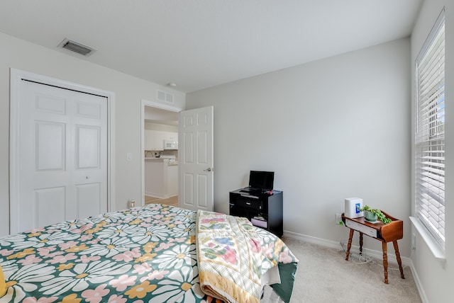 bedroom with visible vents, light carpet, and baseboards