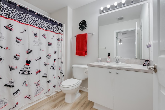 full bath with visible vents, toilet, a ceiling fan, wood finished floors, and vanity