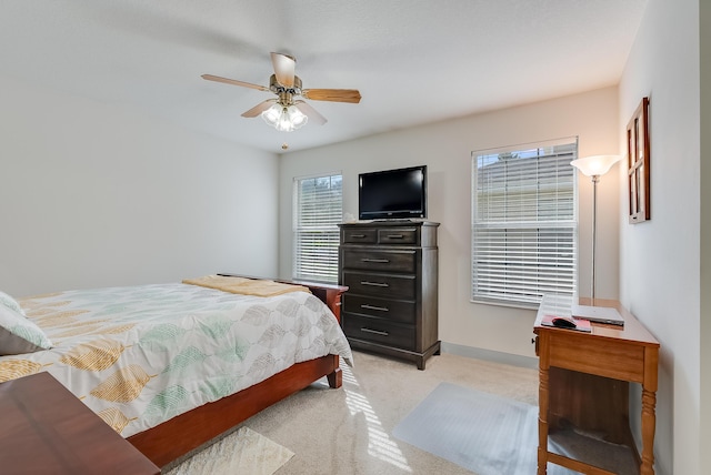 bedroom with a ceiling fan, light colored carpet, and baseboards