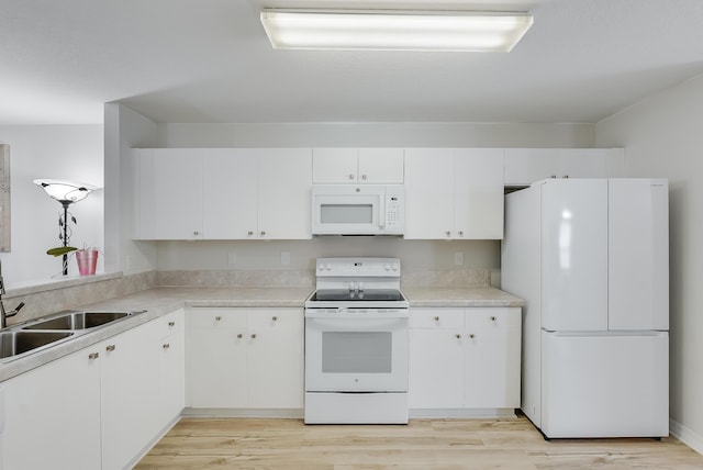 kitchen featuring light wood-type flooring, light countertops, white cabinets, white appliances, and a sink