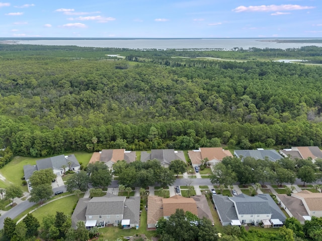 bird's eye view featuring a residential view, a wooded view, and a water view