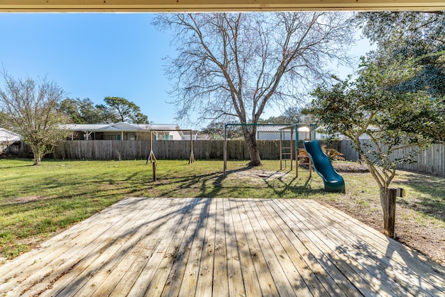 wooden terrace with a yard, a fenced backyard, and a playground