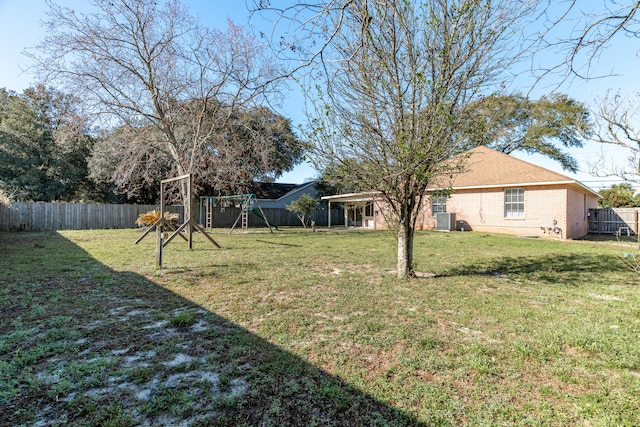 view of yard with cooling unit, a playground, and a fenced backyard