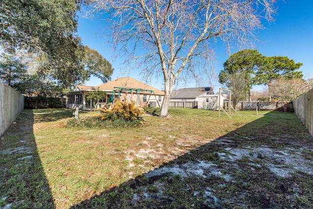 view of yard with an outdoor structure, a storage shed, a fenced backyard, and a sunroom