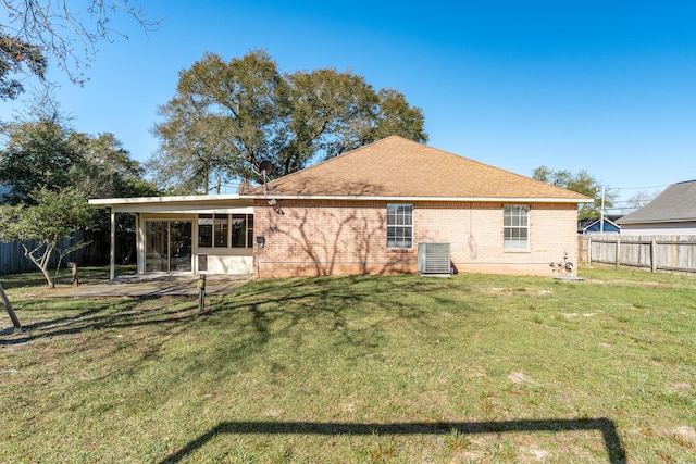 back of property featuring a patio, central AC unit, a yard, a fenced backyard, and brick siding