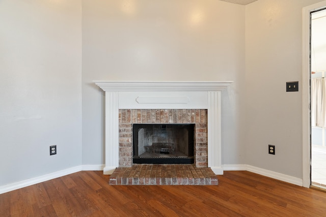 details featuring a fireplace, baseboards, and wood finished floors