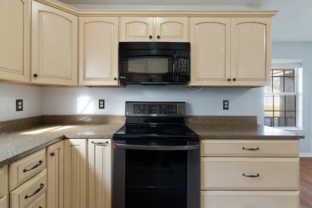 kitchen featuring dark wood-style floors, cream cabinetry, black microwave, and electric range