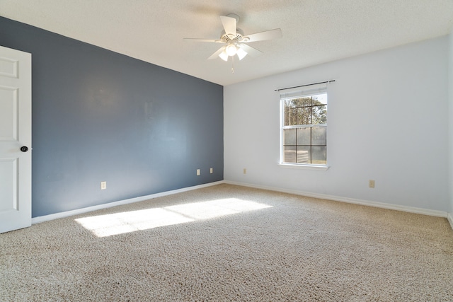 carpeted spare room featuring a textured ceiling, baseboards, and ceiling fan