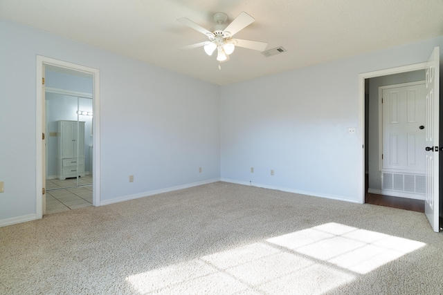 unfurnished bedroom with visible vents, baseboards, connected bathroom, and carpet flooring