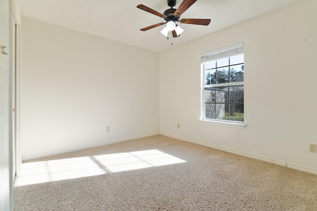 carpeted spare room with baseboards, a textured ceiling, and a ceiling fan