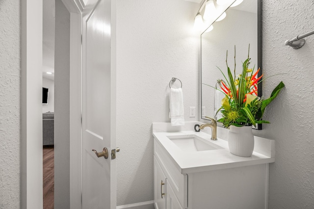 bathroom with vanity and a textured wall