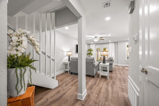 entrance foyer with visible vents, a ceiling fan, wood finished floors, and stairs