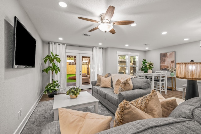 living area featuring visible vents, french doors, baseboards, and a ceiling fan