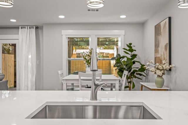 room details with visible vents, recessed lighting, light stone countertops, and a sink